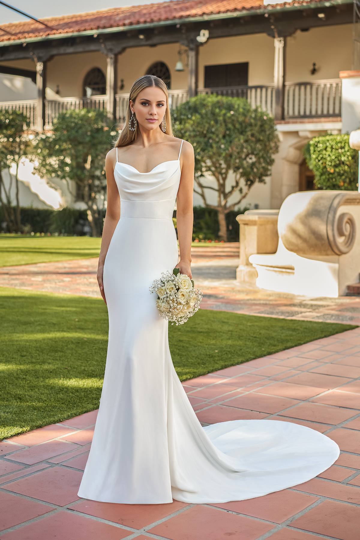 Vestido de novia entallado con cuello en forma de corazón, tirantes finos y largo hasta el suelo.