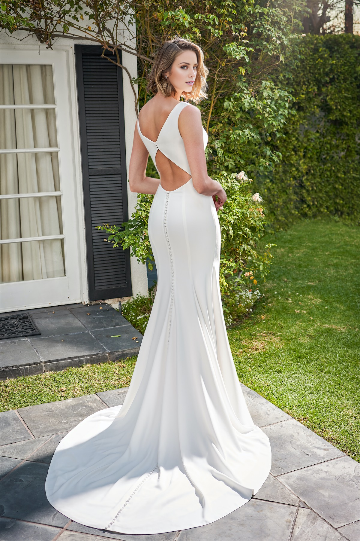 Vestido de novia asimétrico de corte entallado y crepé suave con vuelo.
