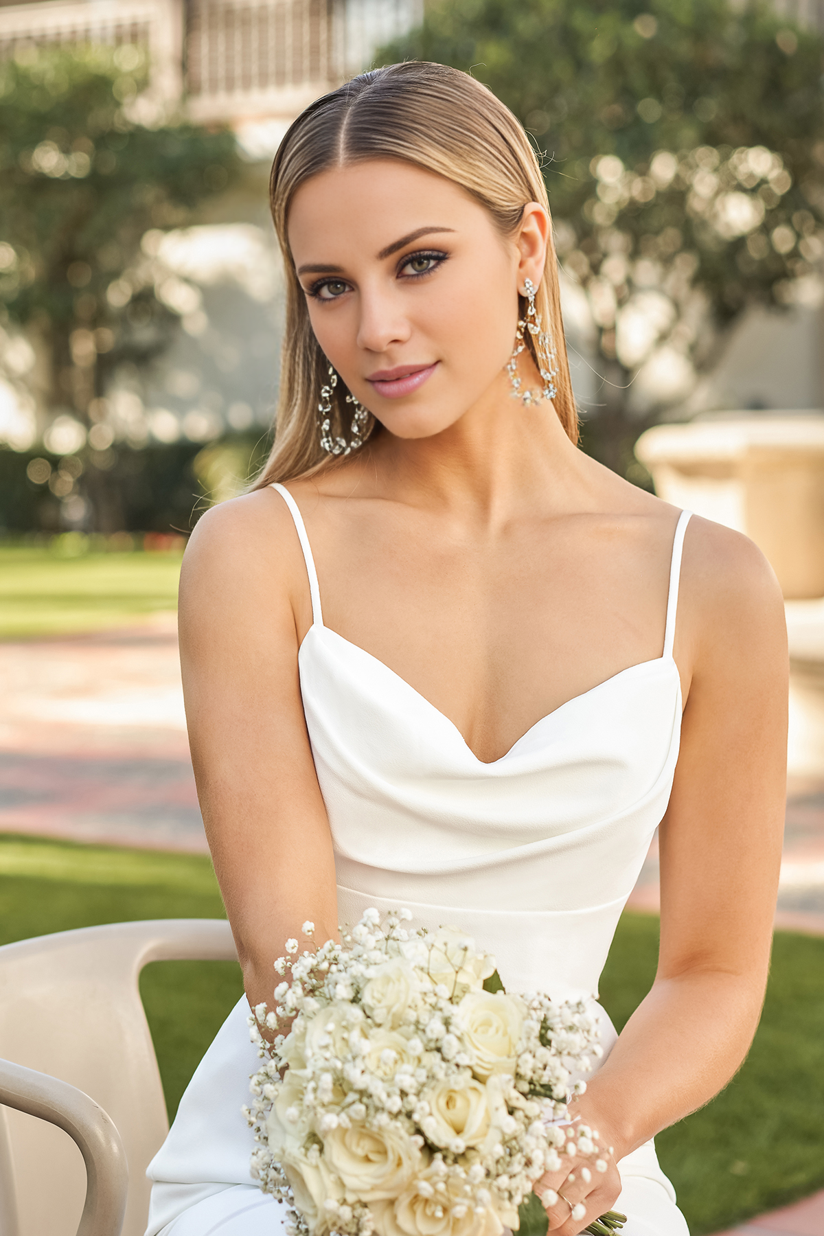 Vestido de novia entallado con cuello en forma de corazón, tirantes finos y largo hasta el suelo.