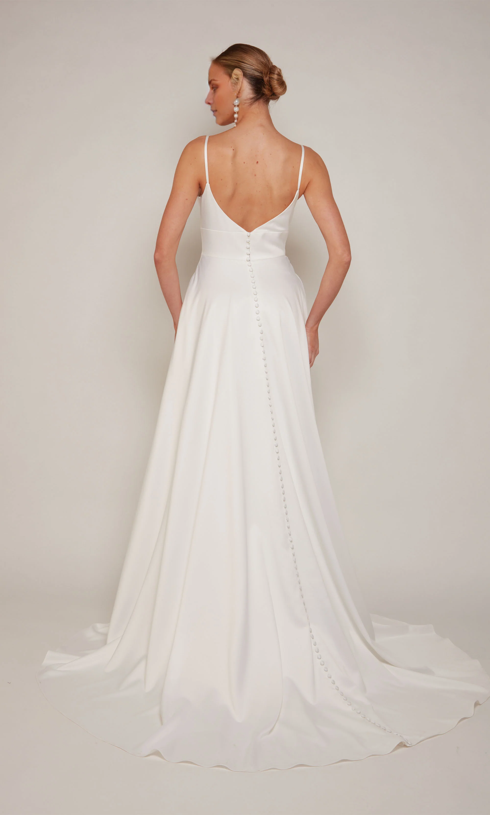 Vestido de novia de satén con escote de pollo, corte A y botones de satén con abertura.