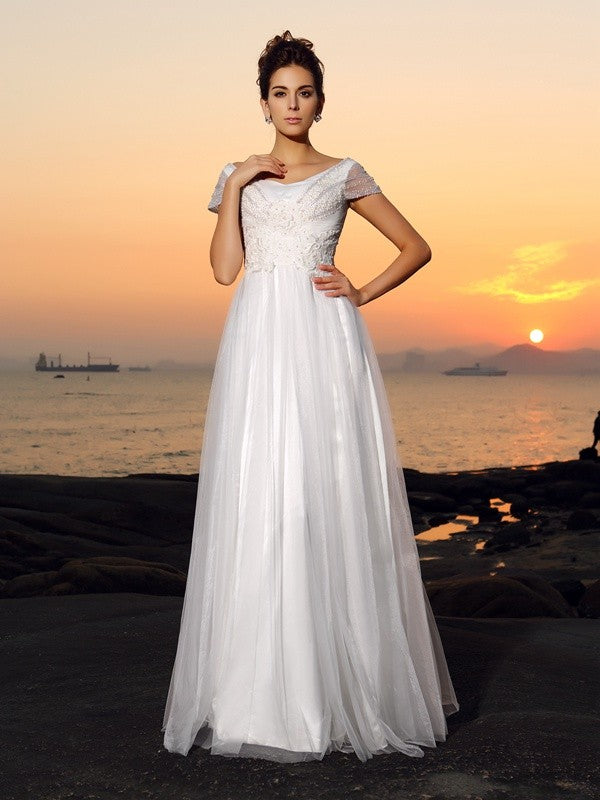 Vestido de novia largo de tul con mangas cortas, corte princesa, hombros descubiertos y cuentas para playa