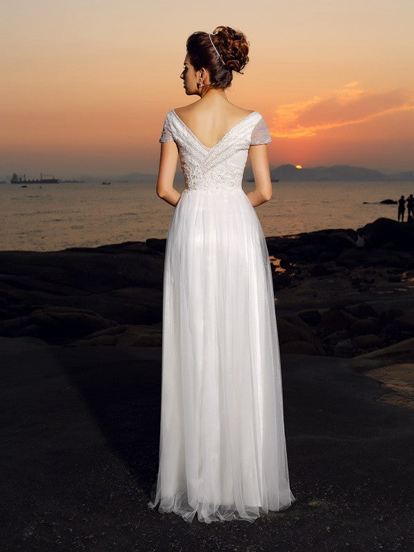 Vestido de novia largo de tul con mangas cortas, corte princesa, hombros descubiertos y cuentas para playa