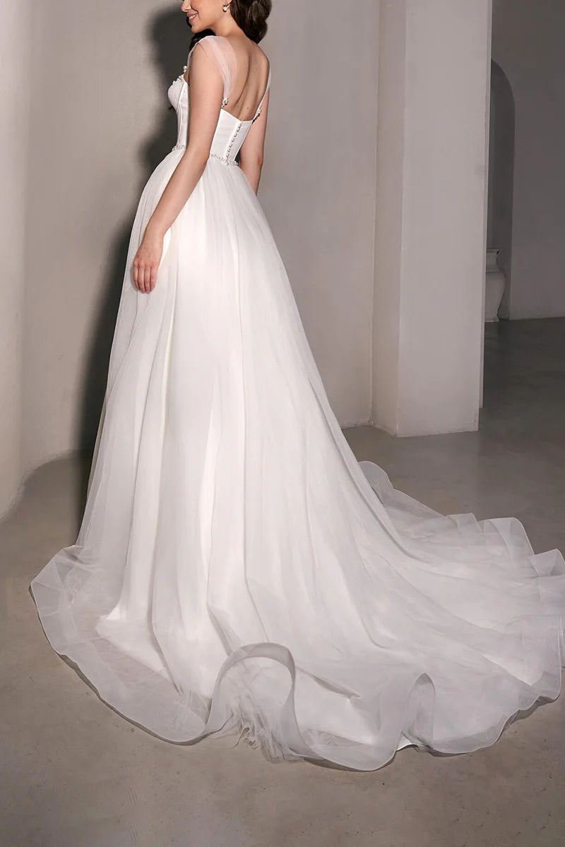 Abito da sposa minimalista trasparente con scollo a cuore e perle