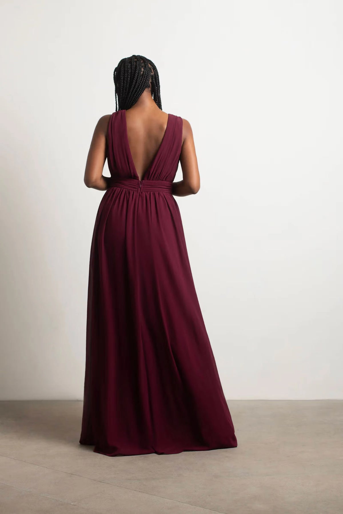 Vestido de fiesta con escote en V profundo, sin mangas, espalda descubierta y largo hasta el suelo. 