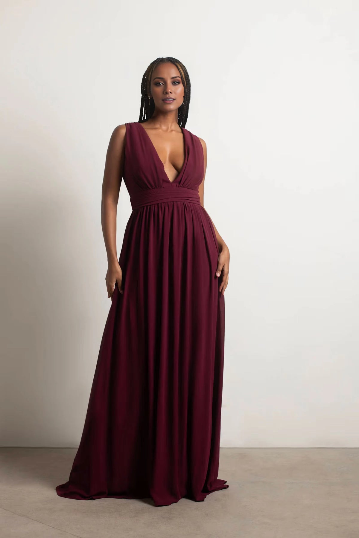 Vestido de fiesta con escote en V profundo, sin mangas, espalda descubierta y largo hasta el suelo. 