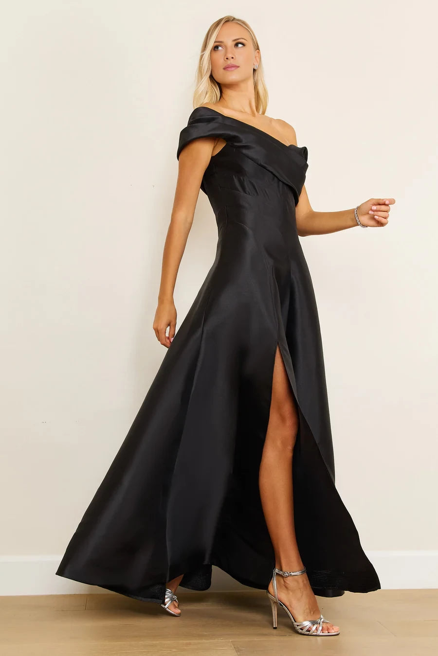 Vestido de fiesta largo hasta el suelo, sin mangas, con cuello asimétrico, hombros descubiertos, detalles plisados, espalda descubierta y abertura lateral. 