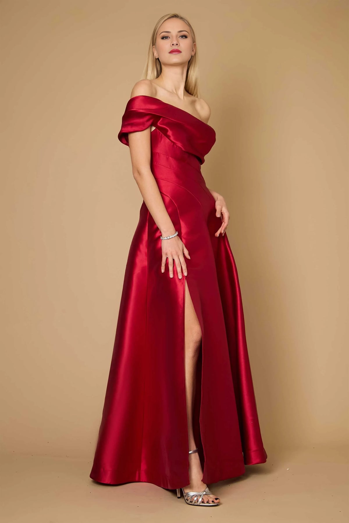 Vestido de fiesta largo hasta el suelo, sin mangas, con cuello asimétrico, hombros descubiertos, detalles plisados, espalda descubierta y abertura lateral. 