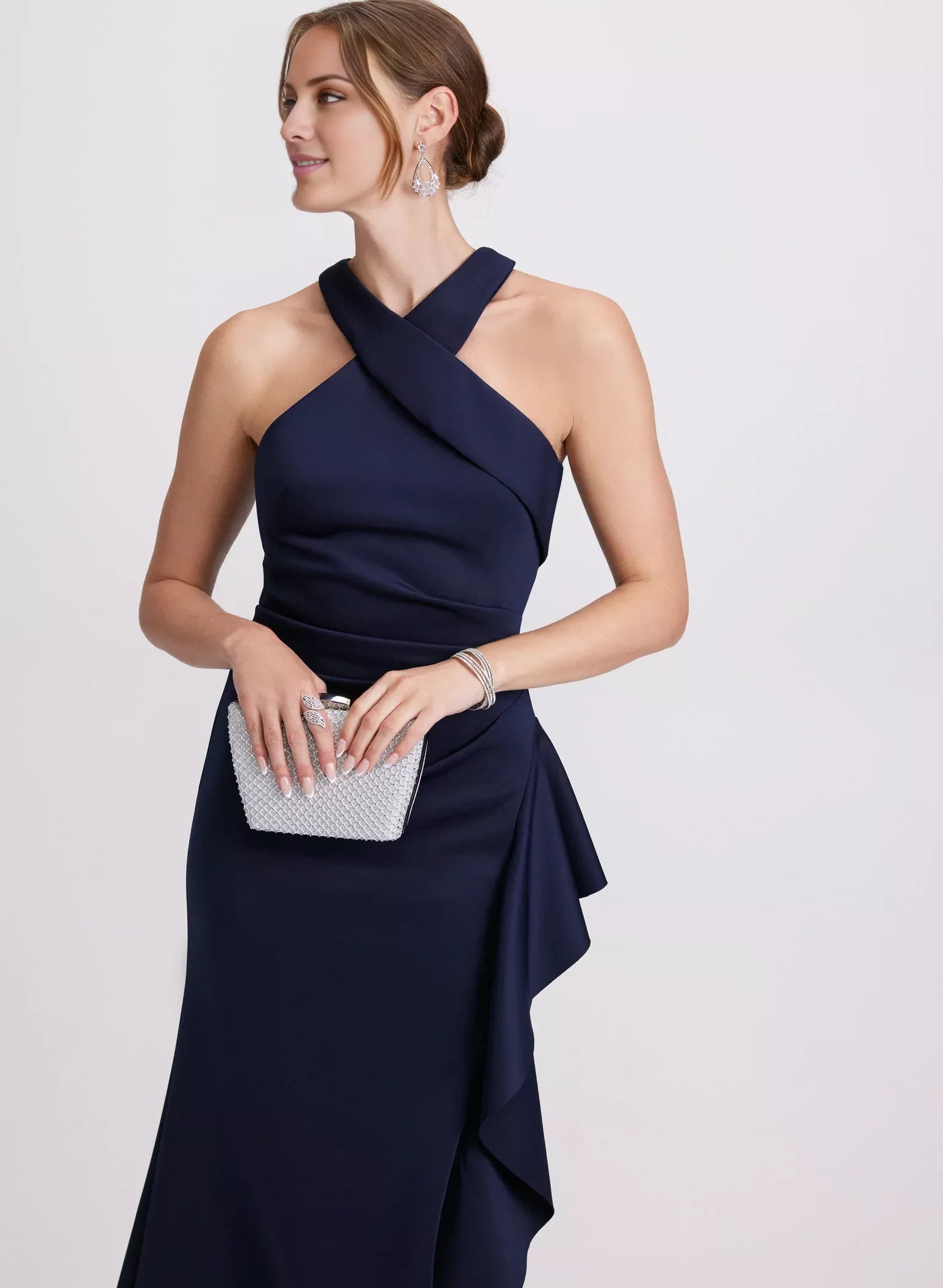 Vestido de noche largo hasta el suelo, sin mangas, con hombros descubiertos, espalda descubierta, borde con volantes y abertura lateral.