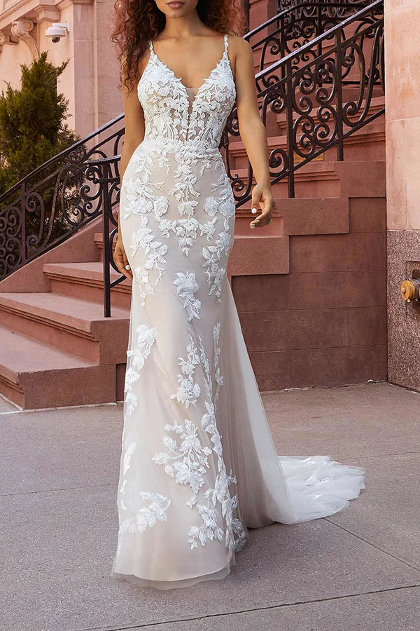 Vestido de novia con cola de pez y finos tirantes de encaje.