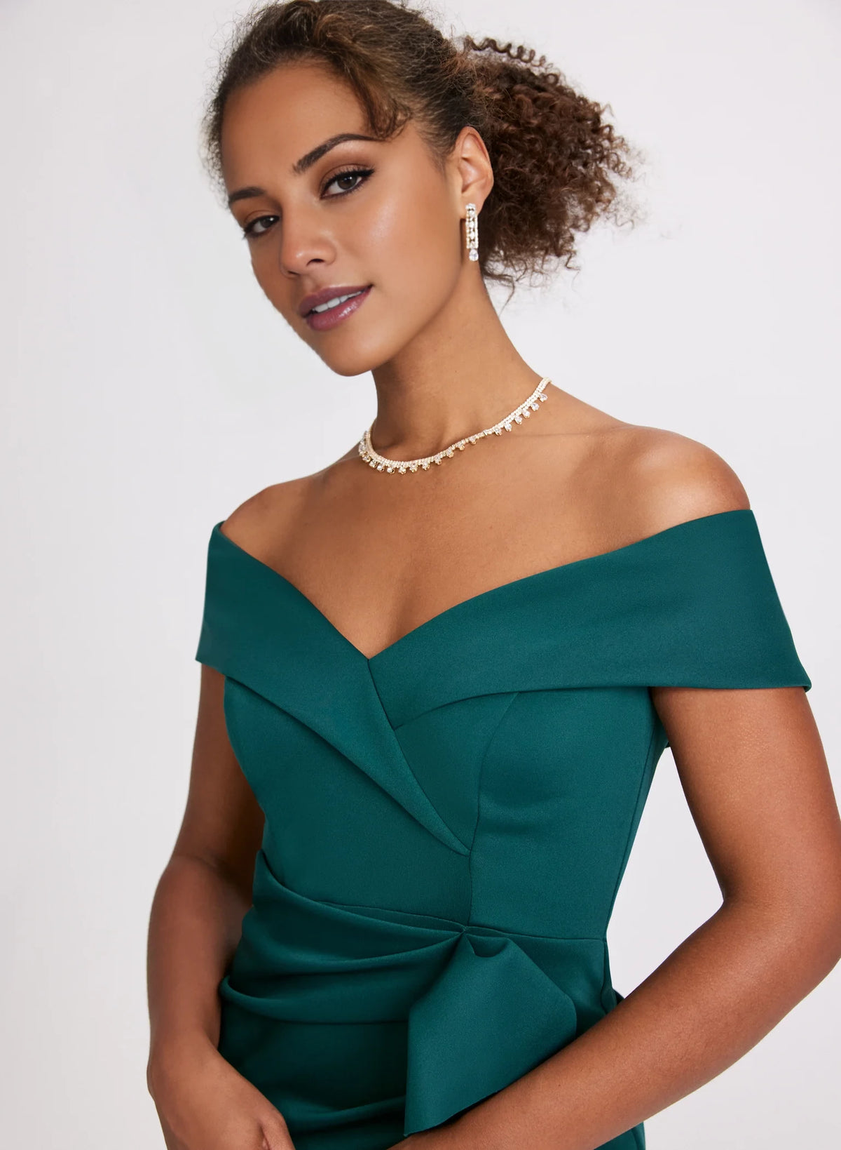 Vestido de fiesta sin mangas, con escote en los hombros, detalles plisados, bordes con volantes y largo hasta el suelo. 