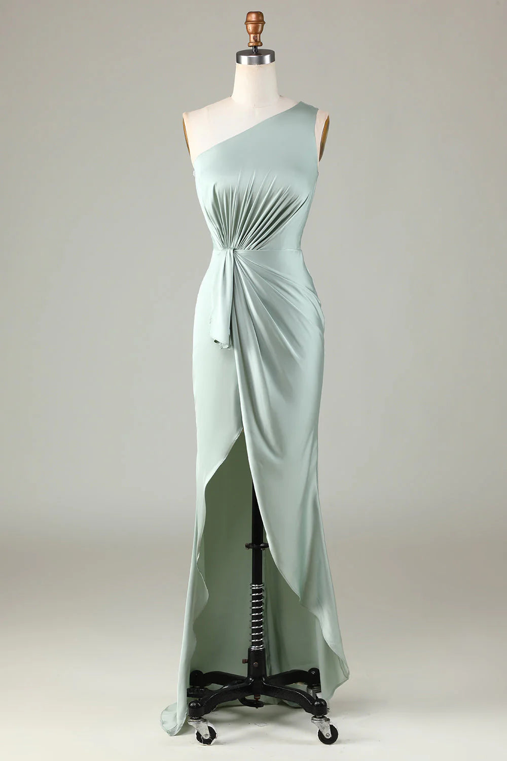 Un vestido de dama de honor en color matcha con hombros descubiertos y bordes con volantes.