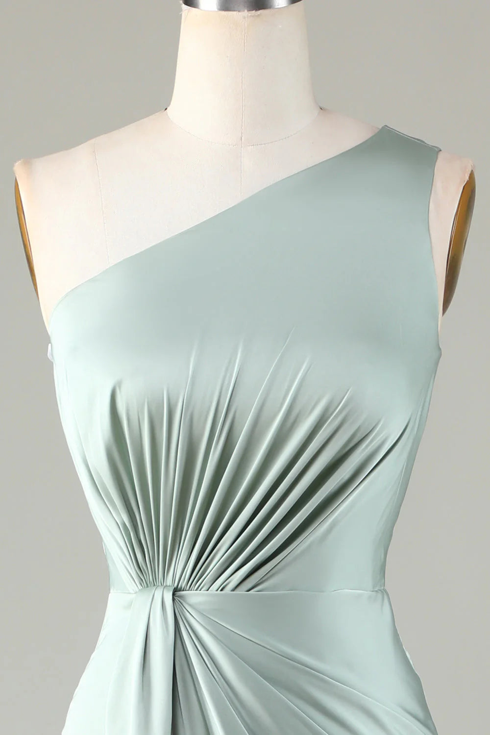 Un vestido de dama de honor en color matcha con hombros descubiertos y bordes con volantes.