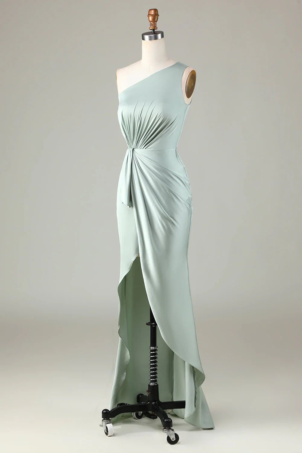Un vestido de dama de honor en color matcha con hombros descubiertos y bordes con volantes.