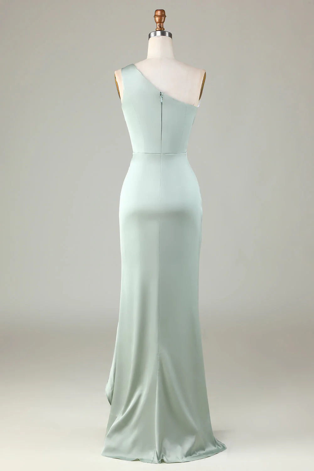 Un vestido de dama de honor en color matcha con hombros descubiertos y bordes con volantes.