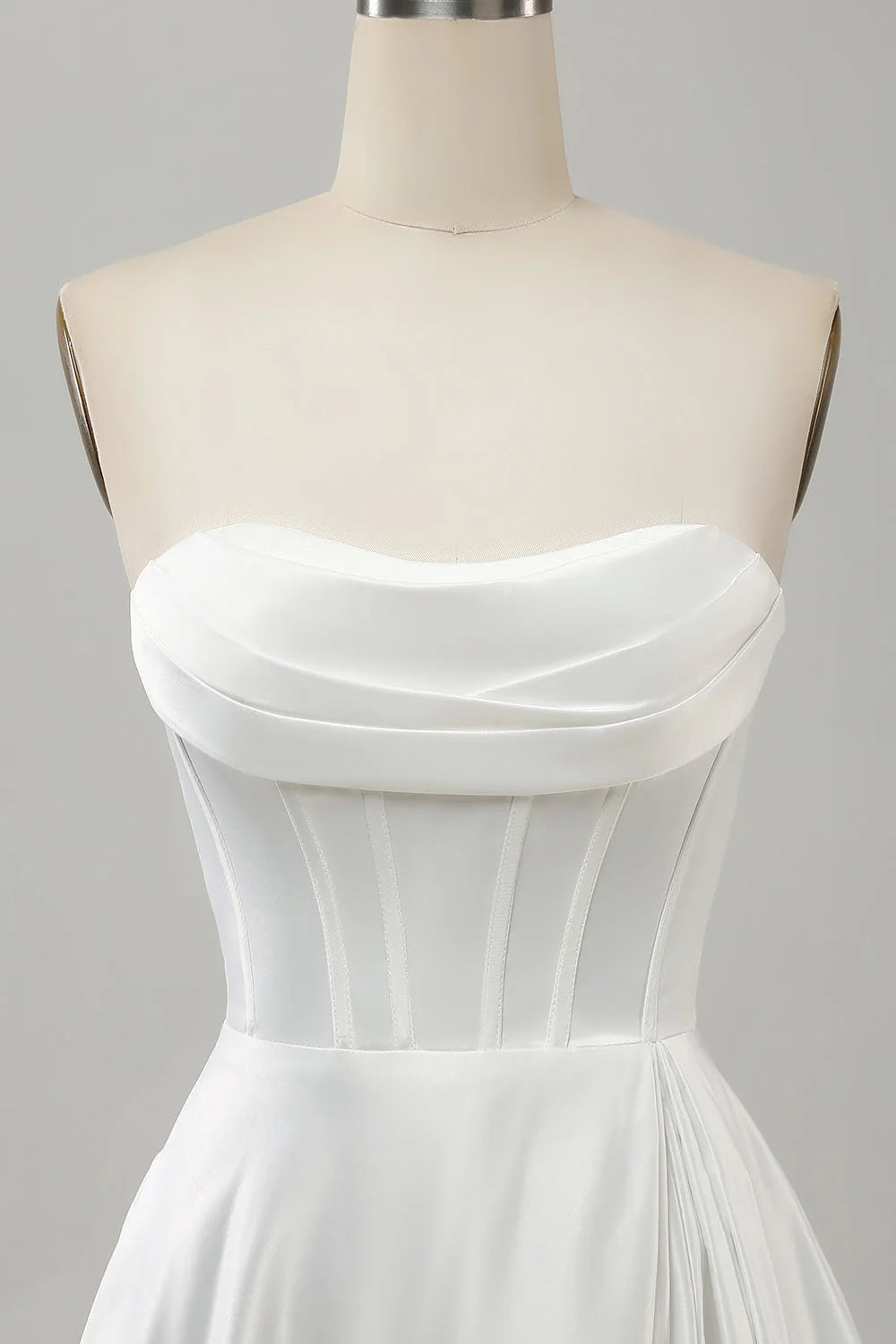 Elegante vestido blanco de corte A sin tirantes, plisado, con abertura lateral.