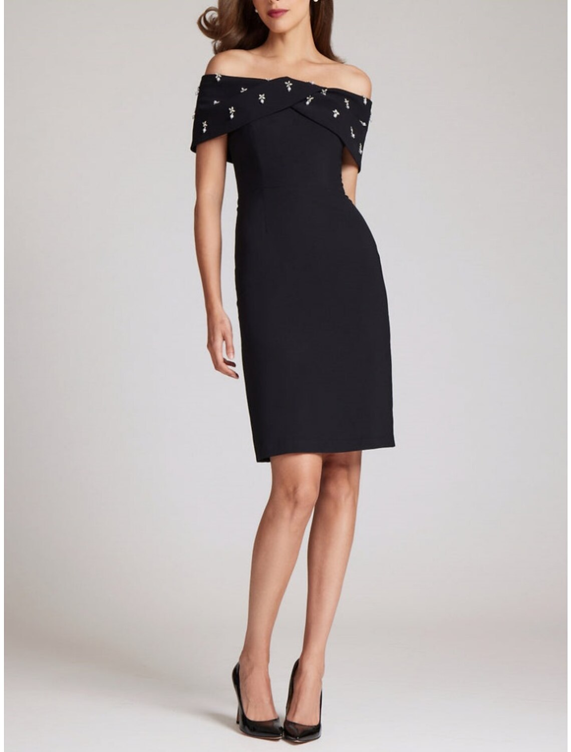 Vestido elegante de fiesta para invitadas de boda, con corte en forma de tubo o columna, largo hasta la rodilla, color negro, manga corta, hombros descubiertos, tela con cristales.