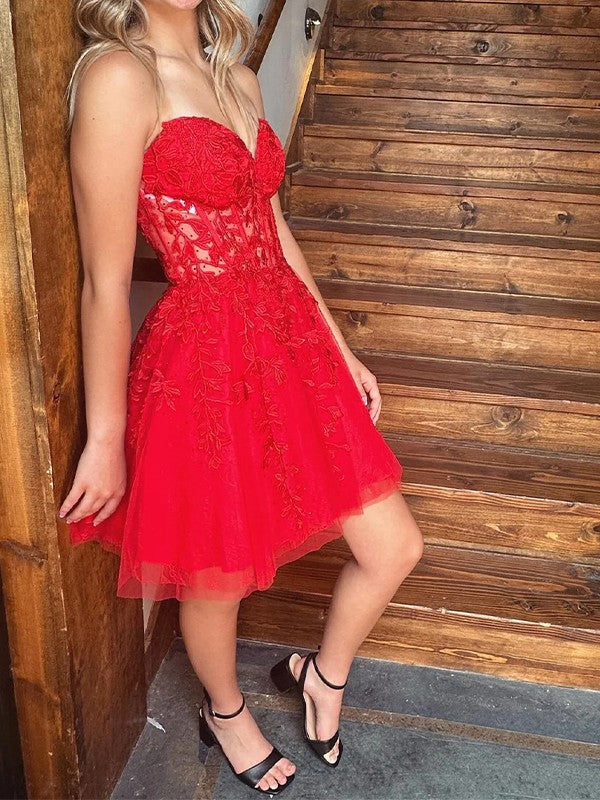 Abito da ballo corto a trapezio con scollo a cuore, senza maniche, in tulle con applicazioni e reggiseno attillato