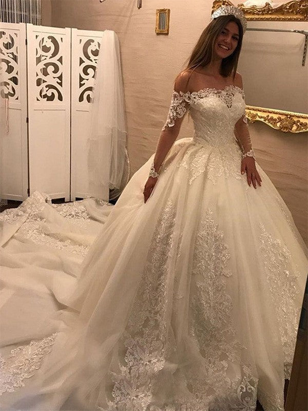 Vestidos de novia de tul con apliques y mangas largas y hombros descubiertos con cola catedral