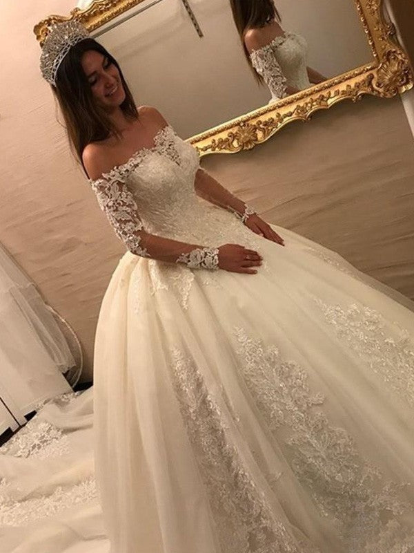 Vestidos de novia de tul con apliques y mangas largas y hombros descubiertos con cola catedral