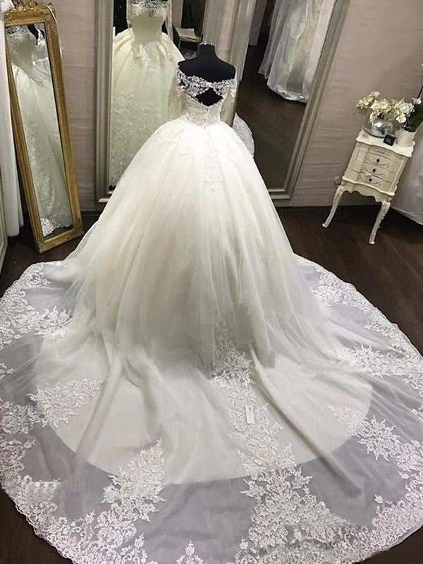 Vestidos de novia de tul con apliques y mangas largas y hombros descubiertos con cola catedral