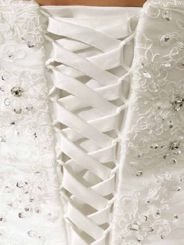 Vestidos de novia de organza con encaje, pliegues y cuentas, sin mangas, sin tirantes y cola catedral