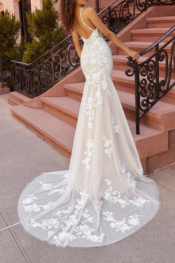 Vestido de novia con cola de pez y finos tirantes de encaje.