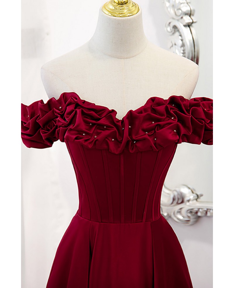 Vestido de fiesta noble y elegante de color rojo vino, sin mangas, con hombros descubiertos, cuentas, tirantes sin espalda en forma de A y dobladillo con volantes hasta el suelo.