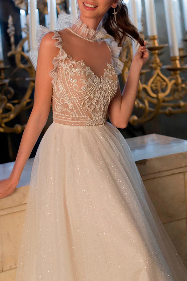 Un abito da sposa bohémien con illusione di filo e perline scintillanti sulla scollatura
