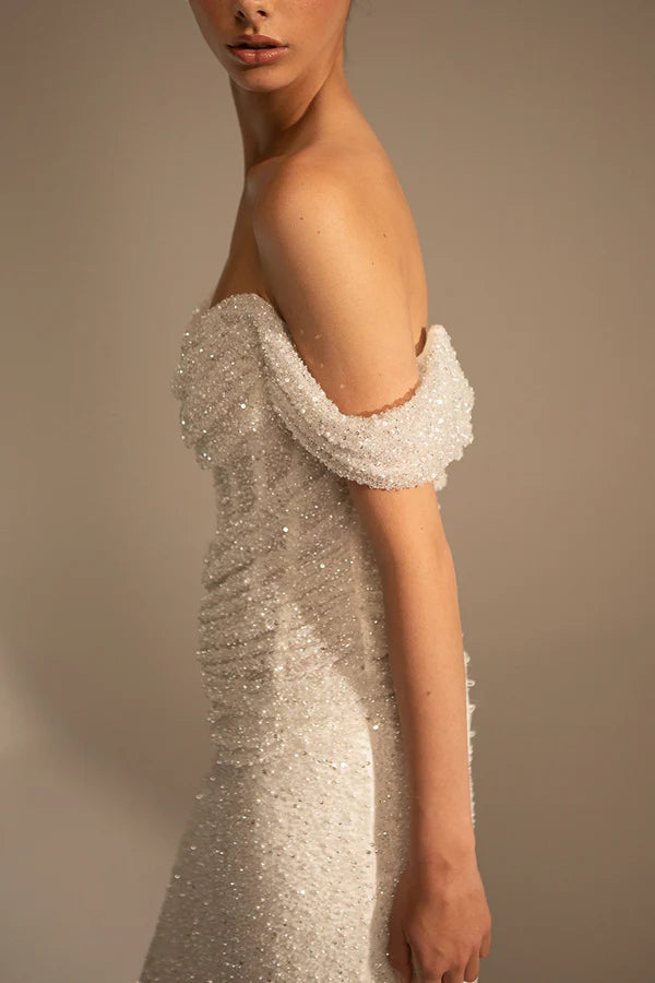 Vestido de novia único con cola de pez plisado y hombros descubiertos combinado con un vestido de novia con cola de corte