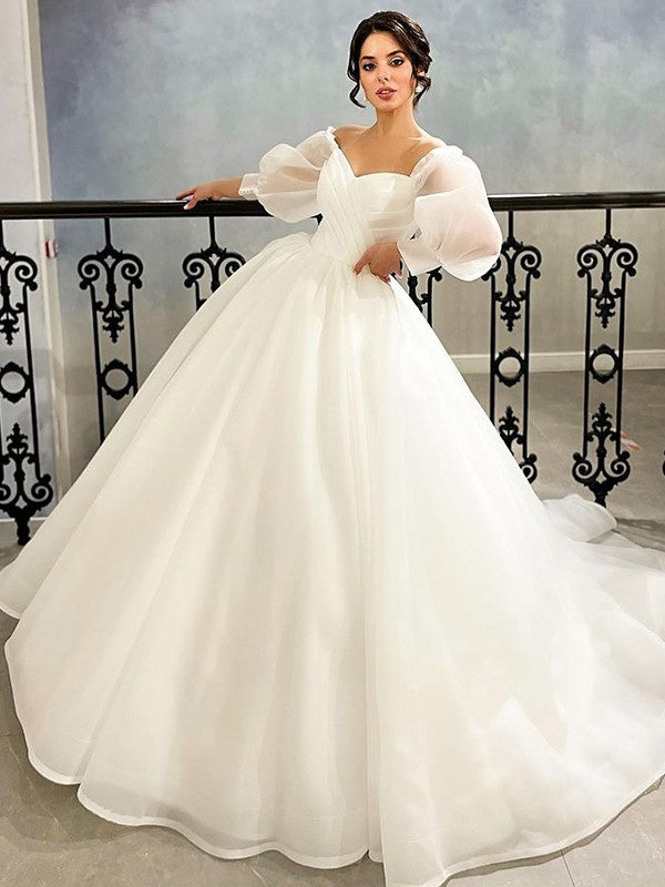 Vestido de novia de organza fruncido con escote corazón y mangas 3/4 con cola de corte