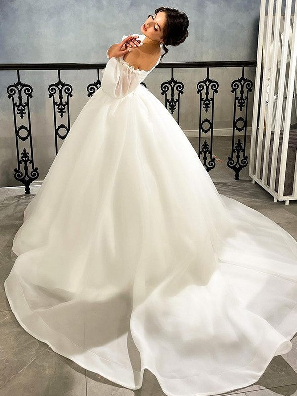 Vestido de novia de organza fruncido con escote corazón y mangas 3/4 con cola de corte